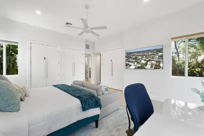 a white bedroom with a bed and a ceiling fan at Sea La Vie FL in Fort Lauderdale