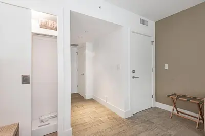 a room with a hallway with white walls and a table at 1 Hotel King Suite 1BR 1 5BA in Miami Beach