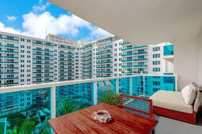 a balcony with a bed and a table and some buildings at 1 Hotel King Suite 1BR 1 5BA in Miami Beach