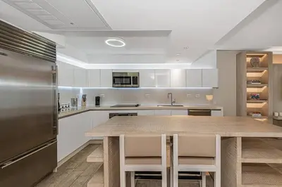 a kitchen with a wooden table and a stainless steel refrigerator at 1 Hotel King Suite 1BR 1 5BA in Miami Beach