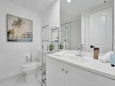 a white bathroom with a toilet and a sink at High floor 2BD with beach service 1608 in Miami Beach