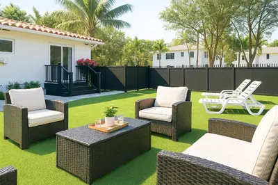 a patio with wicker chairs and a table on grass at Central Miami Oasis, Near Brickell, Grove & Little Havana in Miami