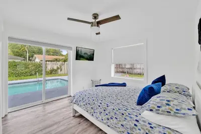 a bedroom with a bed and a swimming pool at Sunny Miami Stay - Pool - BBQ - Centrally Located in Miami