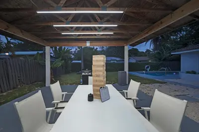 a white table and chairs under a pergola at Sunny Miami Stay - Pool - BBQ - Centrally Located in Miami