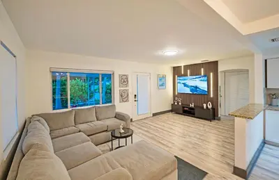 a living room with a couch and a flat screen tv at Sunny Miami Stay - Pool - BBQ - Centrally Located in Miami