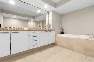 a white bathroom with a tub and a sink at Amazing View Beachfront Resort Luxury Amenities in Hallandale Beach