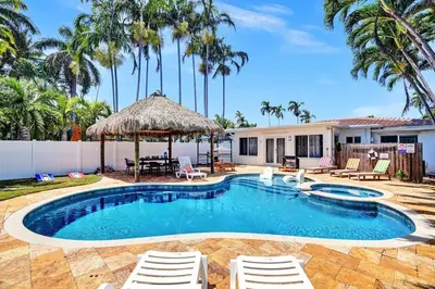 a swimming pool with chairs and a house at Seaside Oasis in Hollywood Lakes near the Beach in Hollywood