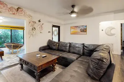 a living room with a leather couch and a table at Walking On Sunshine in Fort Lauderdale