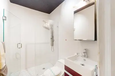 a white bathroom with a sink and a shower at Walking On Sunshine in Fort Lauderdale