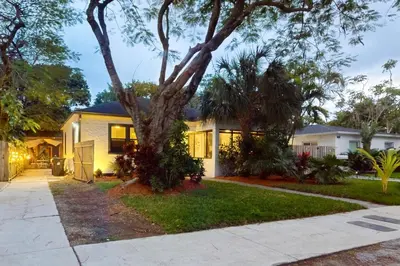 a house with a tree in the front yard at Walking On Sunshine in Fort Lauderdale