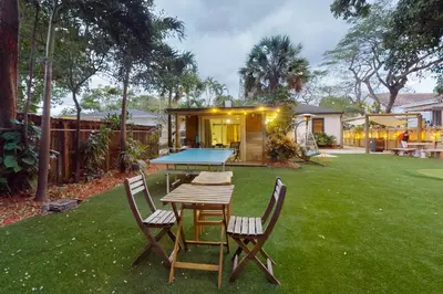 a ping pong table and chairs in a yard at Walking On Sunshine in Fort Lauderdale
