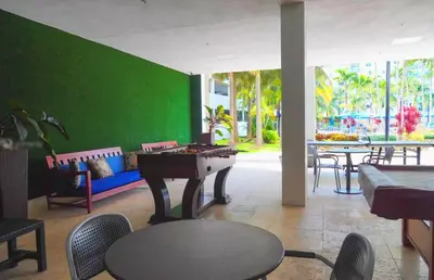 a room with a ping pong table and a green wall at Stunning apt! Oceanview! Parking included in Sunny Isles Beach
