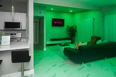 a green living room with a woman sitting on a couch at Miami Luxury Home Rental in Miami