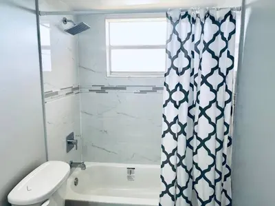 a bathroom with a toilet and a shower curtain at MODERN 2BR 2BA CONDO near AVENTURA! Wi-Fi! Parking in North Miami Beach