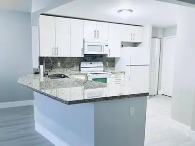 a kitchen with white cabinets and a counter top at MODERN 2BR 2BA CONDO near AVENTURA! Wi-Fi! Parking in North Miami Beach