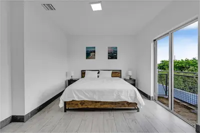 a white bedroom with a bed and a large window at Biscayne Park Villas 15400 in Miami