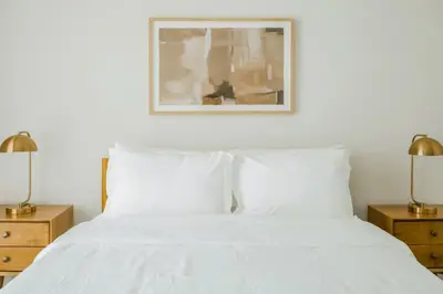 a bedroom with a white bed with two lamps at 1 Mi to Hard Rock Stadium! Chic Retreat with Pool in Joe Robbie Stadium Heliport
