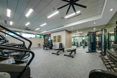 a gym with treadmills and machines in a room at 1 Mi to Hard Rock Stadium! Chic Retreat with Pool in Joe Robbie Stadium Heliport
