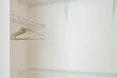 a closet with white walls and a shelf with white shoes at Hard Rock Stadium Home Base! Luxe Condo with Pool in Joe Robbie Stadium Heliport
