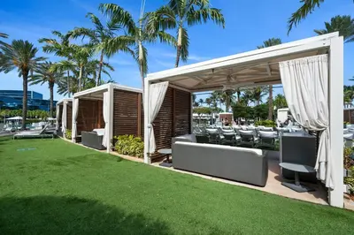 a patio with chairs and a lawn with palm trees at FontaineBleau Resort, with Balcony 10 min from SoBe in Miami Beach