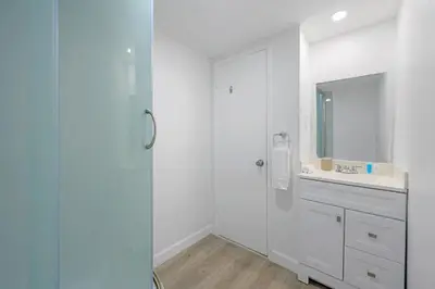 a white bathroom with a sink and a mirror at Beautiful holiday apartment in Ocean Recerve near beach in Sunny Isles Beach