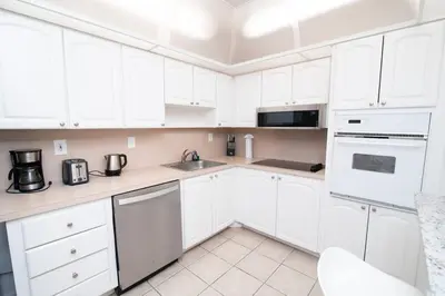 a white kitchen with white cabinets and appliances at Beautiful holiday apartment in Ocean Recerve near beach in Sunny Isles Beach