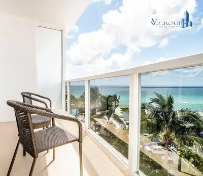 a chair on a balcony with a view of the ocean at Luxurious beachfront studio in Sunny Isles Beach