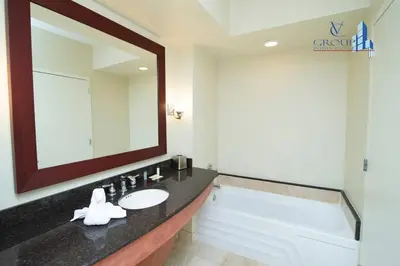 a bathroom with a sink and a mirror and a tub at Luxurious beachfront studio in Sunny Isles Beach