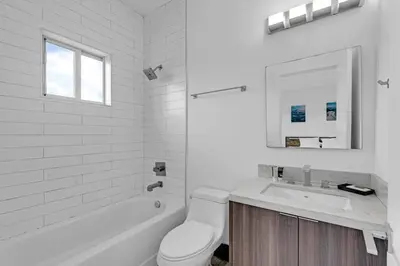 a white bathroom with a toilet and a sink at Biscayne Park Villas 15450 in Miami