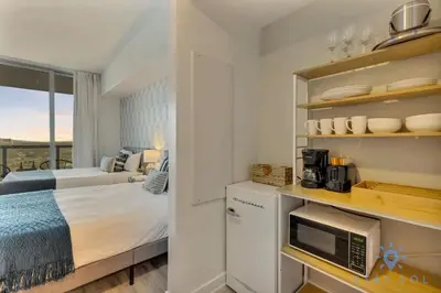 a small bedroom with a bed and a balcony at Modern Resort Apartment with Balcony Pool Gym in Hallandale Beach