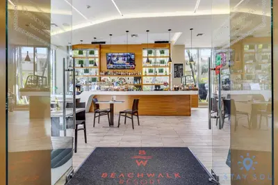a restaurant with a bar and tables and chairs at Modern Resort Apartment with Balcony Pool Gym in Hallandale Beach