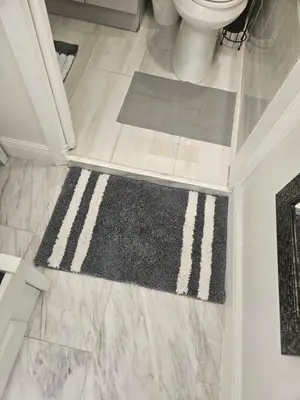 a bathroom with a toilet and a rug on the floor at Jade in Miami