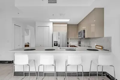 a kitchen with a counter with white stools at Biscayne Park Villas 15440 in Miami