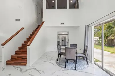 a dining room with a table and chairs on a marble floor at Spacious 3BR Villa in Miami with Fenced Backyard in Miami
