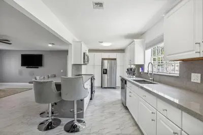 a kitchen with a counter and two bar stools at Spacious 3BR Villa in Miami with Fenced Backyard in Miami