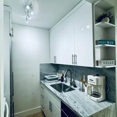 a kitchen with white cabinets and a sink at BRAND NEW! Lovely 1 Bedroom with Pool by the Beach in Miami