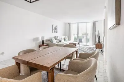 a living room with a wooden table and chairs at Beachfront, Pools, Patio, King Bd Villa- Hollywood FL in Hollywood