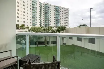 a balcony with two chairs and a building at Beachfront, Pools, Patio, King Bd Villa- Hollywood FL in Hollywood