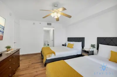 a bedroom with two beds and a ceiling fan at Confortable Apartment with pool and gym in Miami