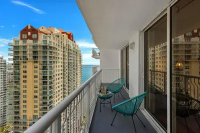 a balcony with two chairs and a table at Confortable Apartment with pool and gym in Miami