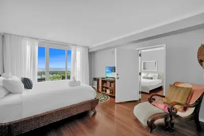 a white bedroom with a bed and a window at Astonishing SEA VIEW Studio in Grove in Miami