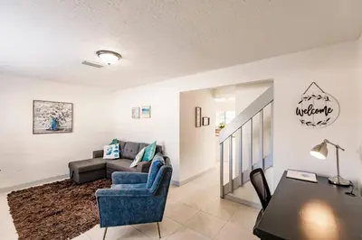 a living room with a blue chair and a couch at Miami Oasis 7 mins to Dolphin Mall MIA PS4 Games in Miami