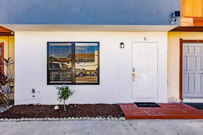 a white house with a window and a door at Miami Oasis 7 mins to Dolphin Mall MIA PS4 Games in Miami
