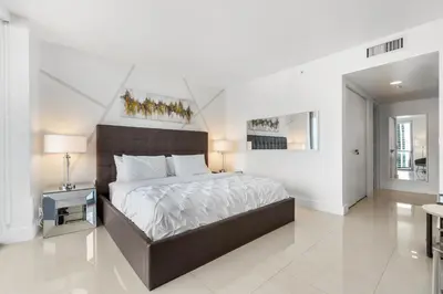 a bedroom with a large bed in a white room at Spacious Luxury Apartment at Beachwalk Resort with Ocean Views and Private Foyer in Hallandale Beach