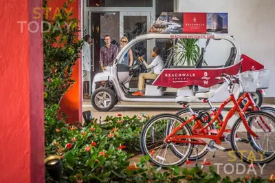 a small car with bikes parked in front of it at Spacious Luxury Apartment at Beachwalk Resort with Ocean Views and Private Foyer in Hallandale Beach