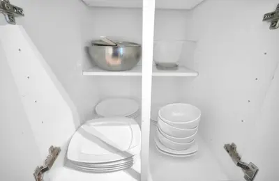 two views of a white cabinet with a toilet and plates at Tropical Paradise Spacious 3 bedroom in Miami