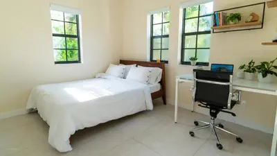 a bedroom with a bed and a desk and a chair at Villa Viscayne - Miami Modern Luxury with Pool & Spa in Biscayne Park