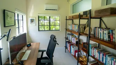 an office with a desk and book shelves with books at Villa Viscayne - Miami Modern Luxury with Pool & Spa in Biscayne Park
