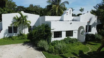 a white house with a palm tree in front of it at Villa Viscayne - Miami Modern Luxury with Pool & Spa in Biscayne Park