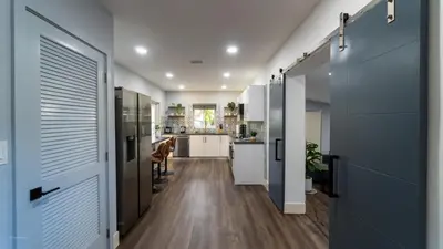 a hallway of a kitchen with a door open at Villa Tropical - Your private Miami Resort with a heated pool in North Miami